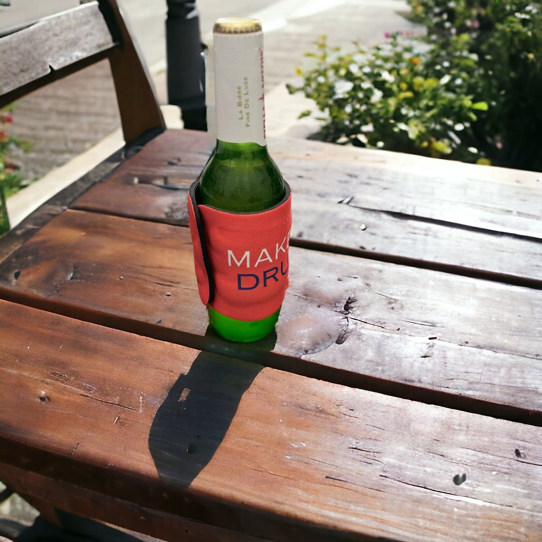 Outdoor shot of a beer bottle covered with a vibrant red koozie featuring 'America Again' text, perfect for personalized gift options