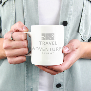 Hands holding a white mug with 'Travel Adventures by Holly' logo, perfect for personalized products and custom drinkware promotions.