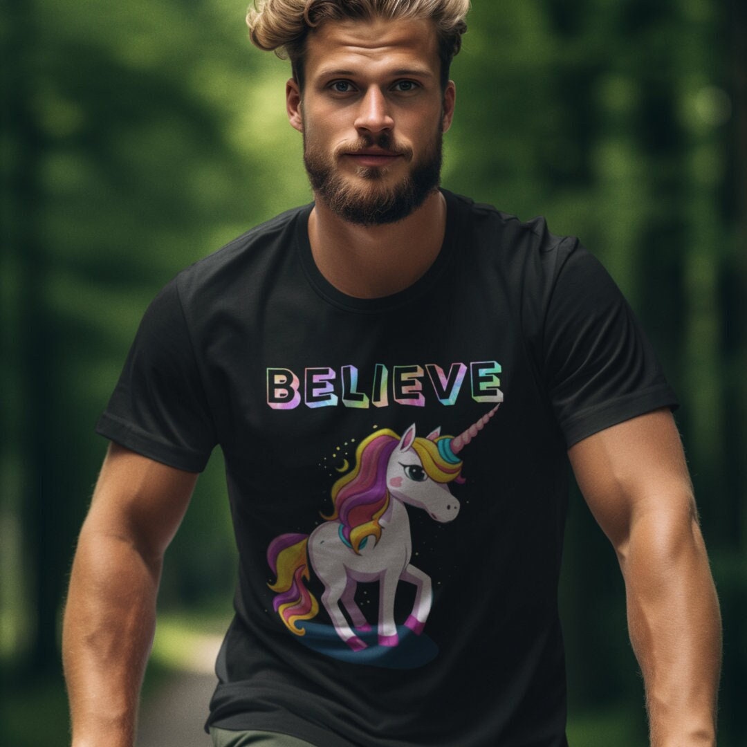 Man wearing black tee shirt with unicorn and Believe text