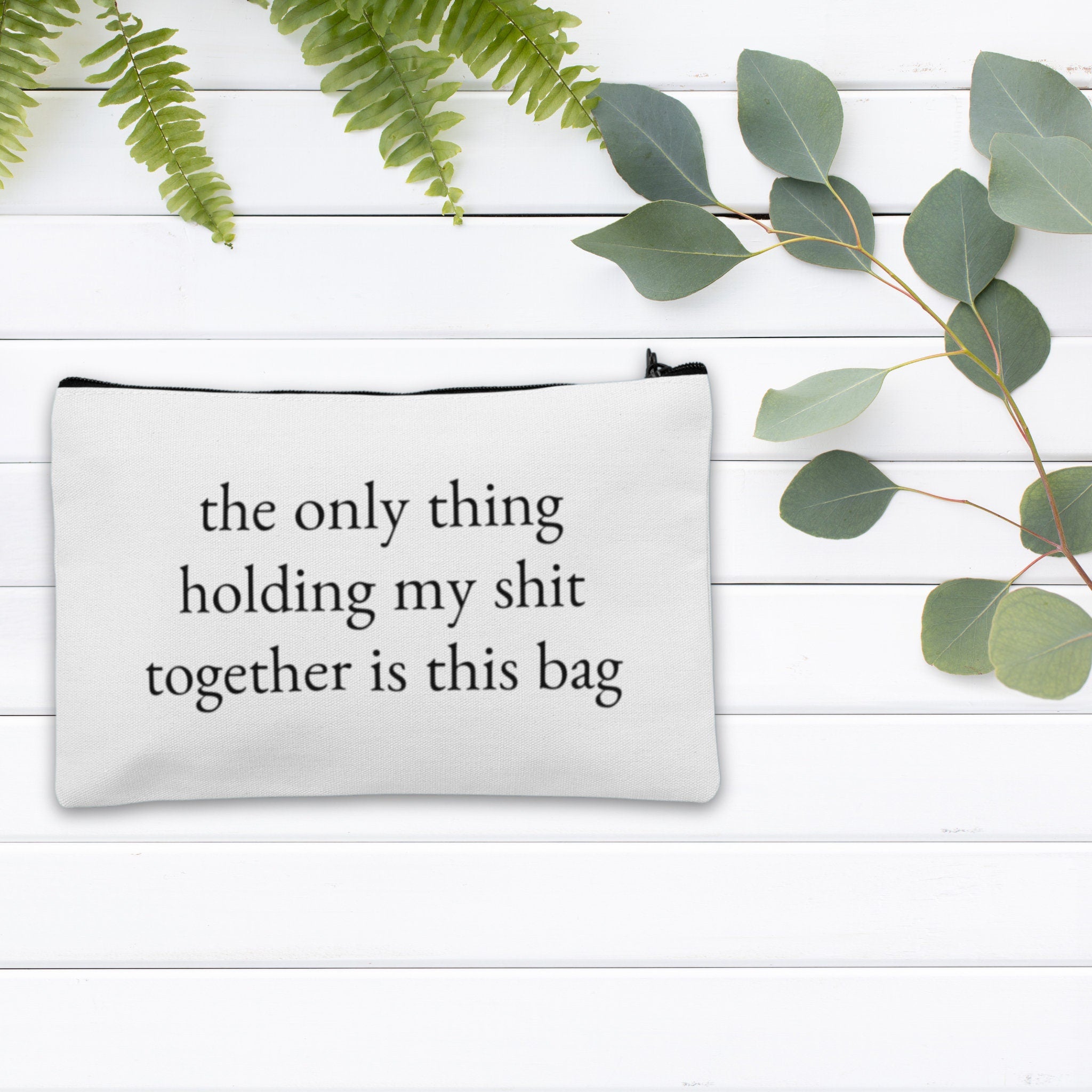 A custom makeup bag with the phrase 'The Only Thing Holding My Shit Together Is This Bag,' making it a funny and practical gift for women. Perfect for those looking for unique and humorous cosmetic bags.