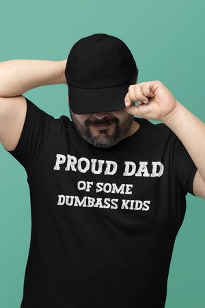 A man wearing a black shirt with the phrase 'Proud Dad of Some Dumbass Kids,' making it a humorous and custom Father's Day gift for dads. Ideal for those seeking unique and funny dad shirts.