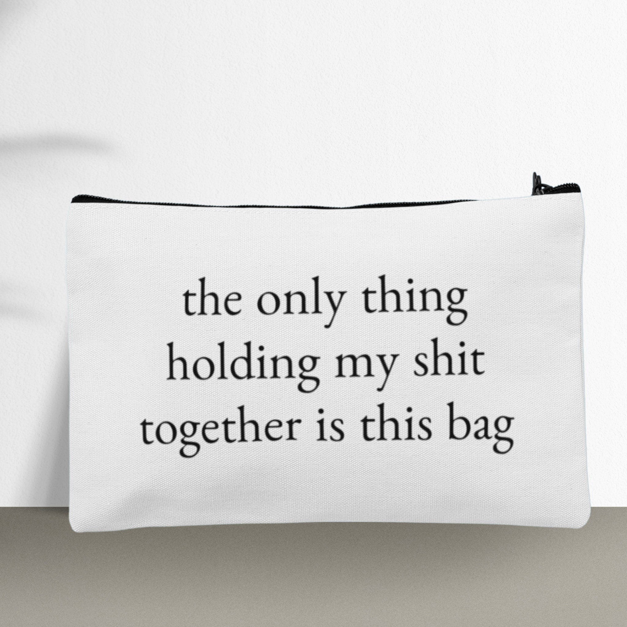 A custom makeup bag with the phrase 'The Only Thing Holding My Shit Together Is This Bag,' making it a funny and practical gift for women. Perfect for those looking for unique and humorous cosmetic bags.