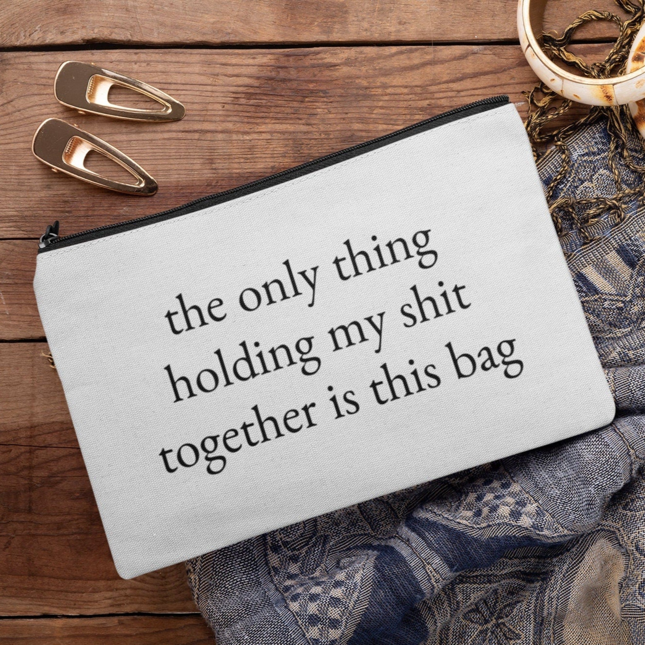 A custom makeup bag with the phrase 'The Only Thing Holding My Shit Together Is This Bag,' making it a funny and practical gift for women. Perfect for those looking for unique and humorous cosmetic bags.