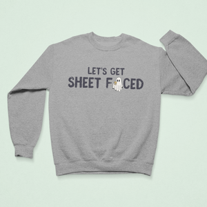 Gray cozy sweatshirt with the humorous Halloween-themed text "Let's Get Sheet Faced" featuring a small ghost illustration, perfect for festive or casual wear.