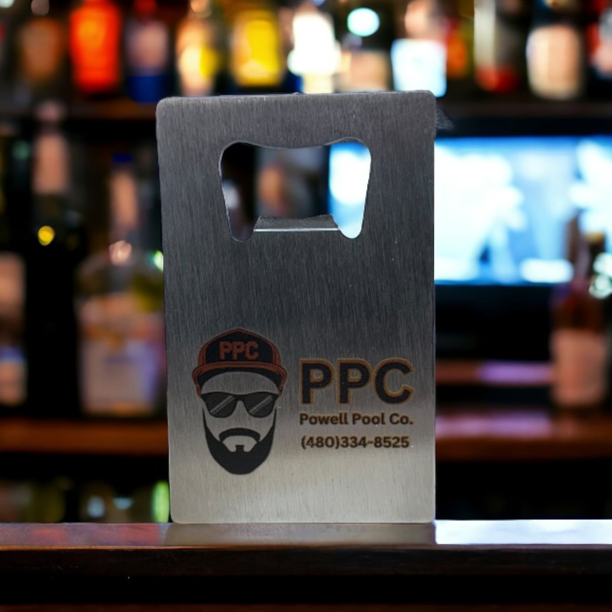 Metal custom bottle opener business card with "PPC Powell Pool Co." logo and contact information, featuring a bearded man wearing sunglasses and a hat, ideal for pool service branding and promotional items.